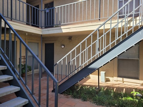 A staircase with a metal railing leads to a balcony.