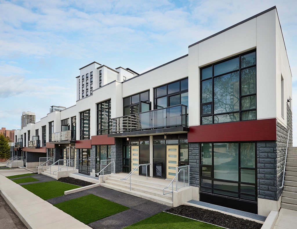 A modern building with a red awning and a balcony.