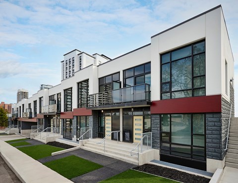 A modern building with a red awning and a balcony.
