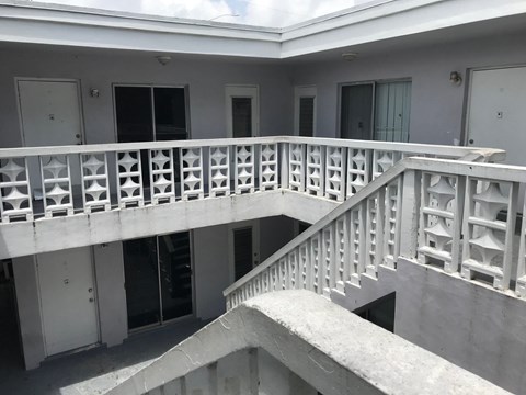A white balcony with a staircase leading to a second floor.