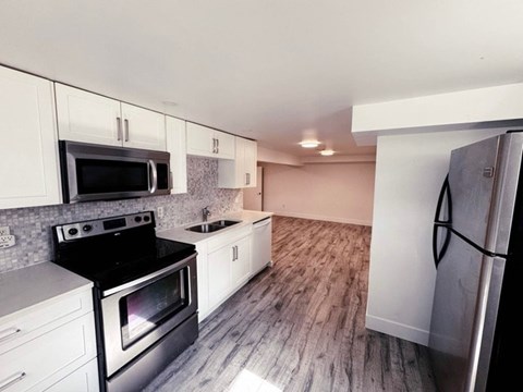 A kitchen with white cabinets and a black stove top oven.