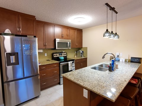 A kitchen with granite countertops and stainless steel appliances.