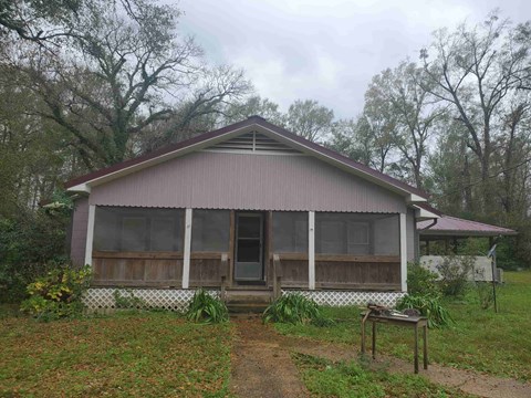 A house with a brown roof and a white fence.