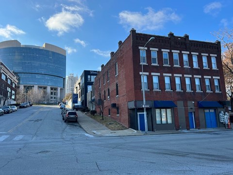 A street view of a city with a red brick building on the right.