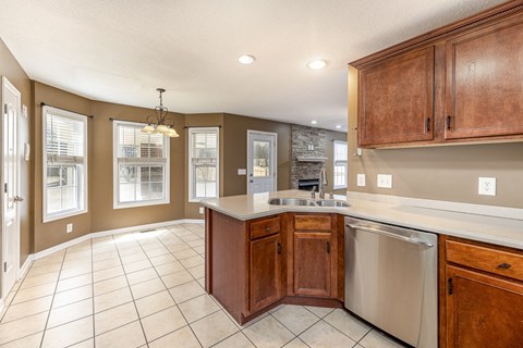 A kitchen with brown cabinets and a stainless steel dishwasher.