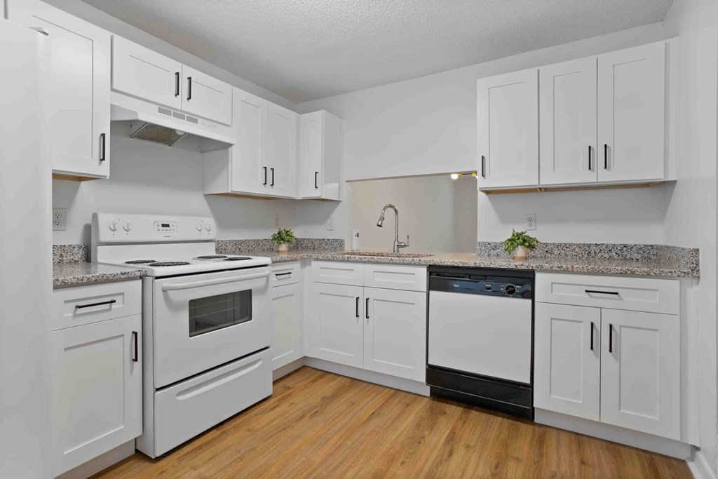A kitchen with white cabinets and appliances.