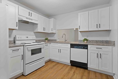 A kitchen with white cabinets and appliances.