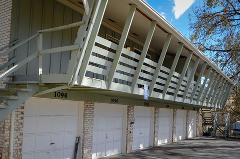 A building with a balcony and garage doors.