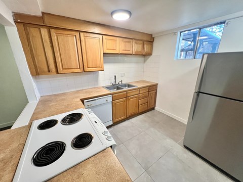 A kitchen with a stove top oven and a refrigerator.