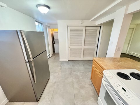 A kitchen with a stainless steel refrigerator and a white stove top oven.