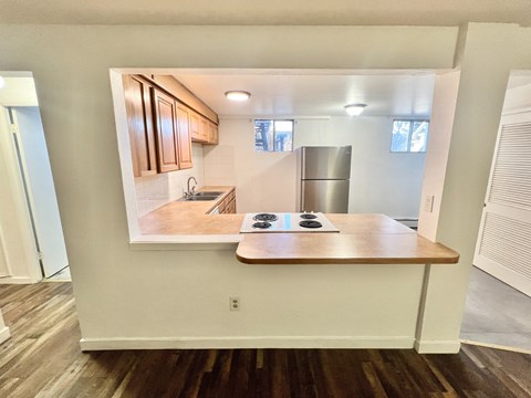 A kitchen with a stove top oven and a fridge.