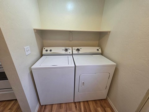 A white dryer and washer in a small room.