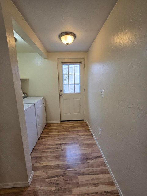 A hallway with a white door and a light on the ceiling.
