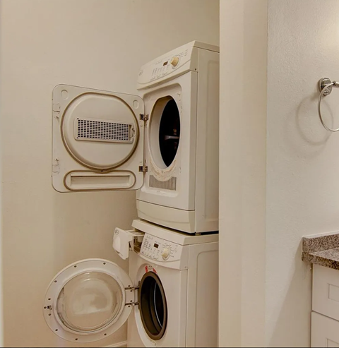A white washing machine and dryer stacked on top of each other.