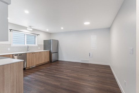 A kitchen with wooden floors and white walls.