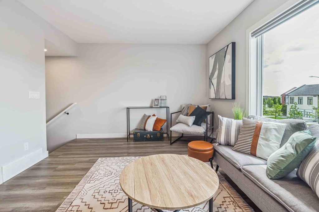 A living room with a grey couch and a wooden coffee table.