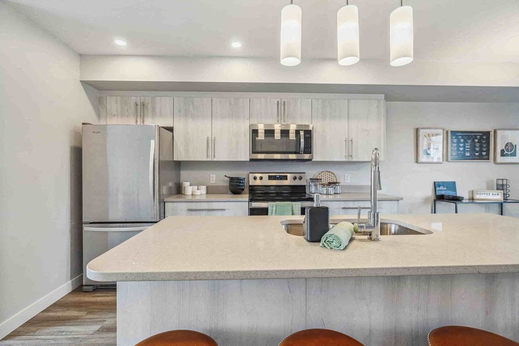 A modern kitchen with a large island and stainless steel appliances.