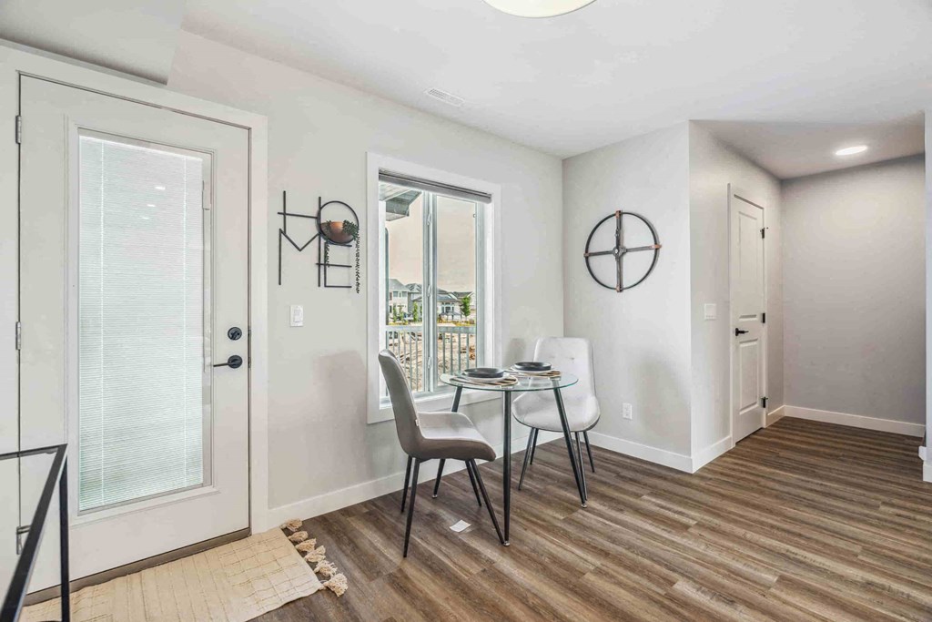 A dining room with a table and chairs.