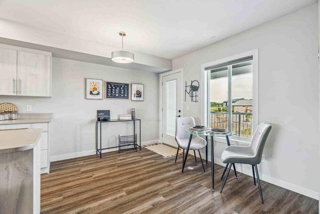 A kitchen with a table and chairs in front of a window.
