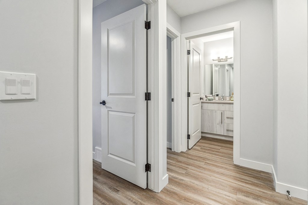 A white bathroom with a white door and a white cabinet.