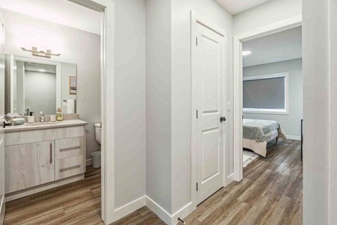 A small bedroom with a bed, dresser, and mirror.