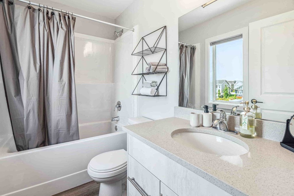 A bathroom with a white toilet, a white sink, and a white bathtub.