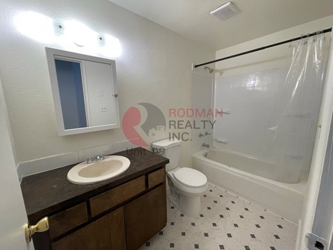 A bathroom with a sink, toilet, and bathtub.