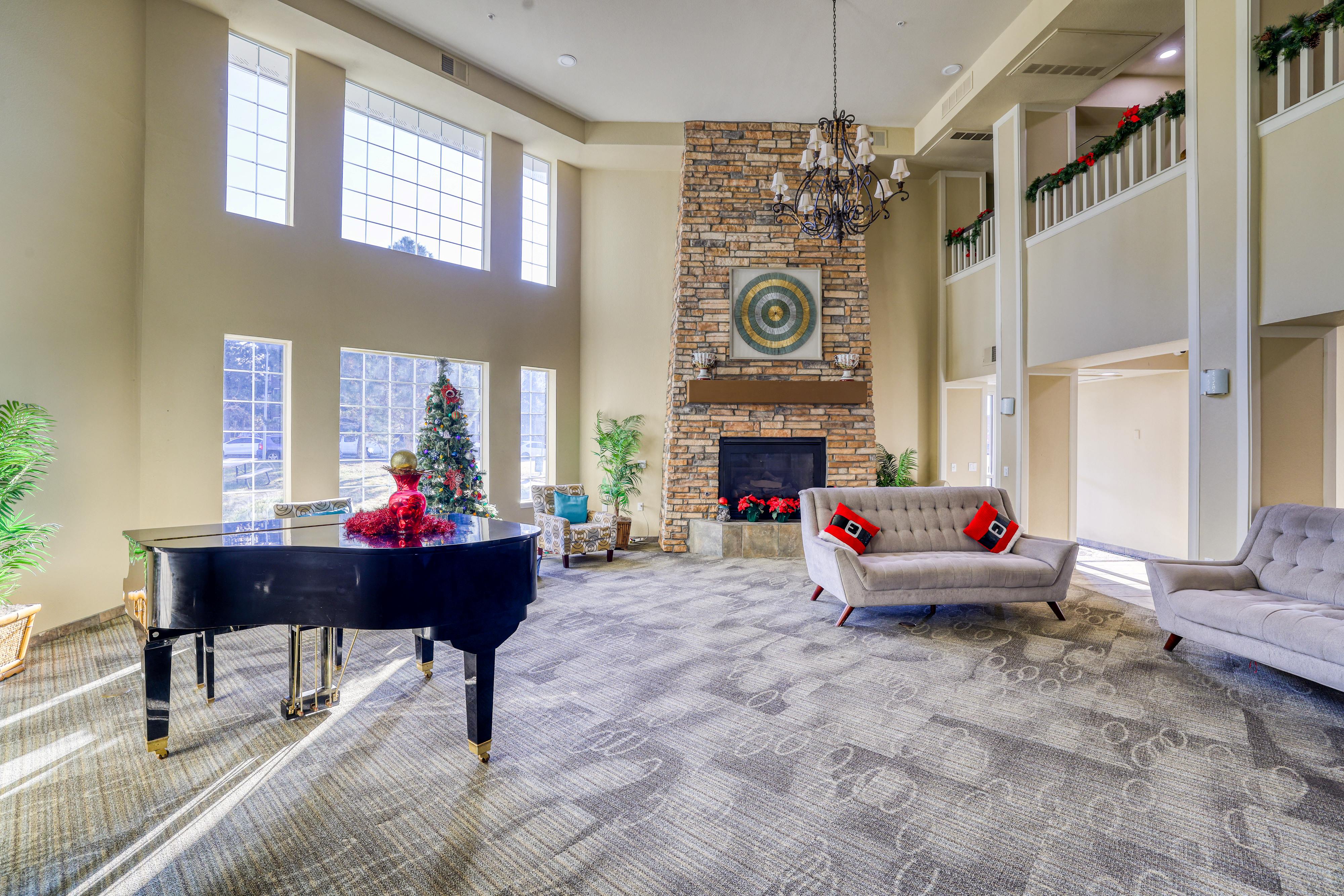 A living room with a piano, a fireplace, and a couch.