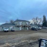 A house with a car parked in front.