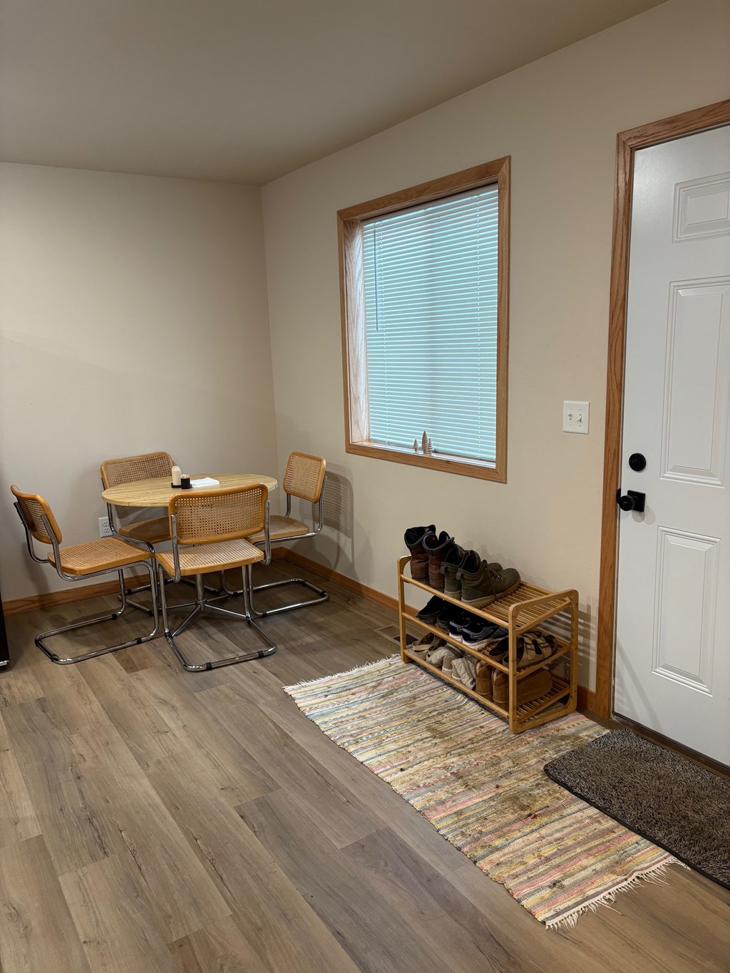 A room with a table and chairs and a rug.