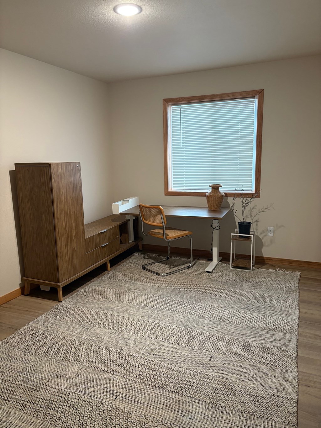 A room with a desk, chair, and cabinet.