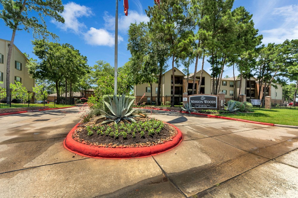 A sign that says "Vision Woods" is in front of a building.