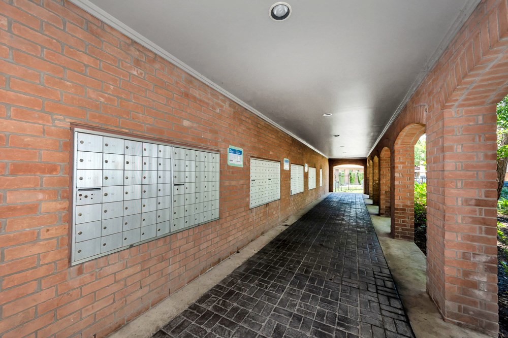 A long corridor with brick walls and a tiled floor.