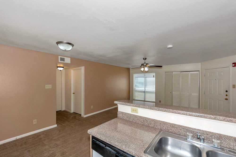 A kitchen area with a sink, stove, and a window.