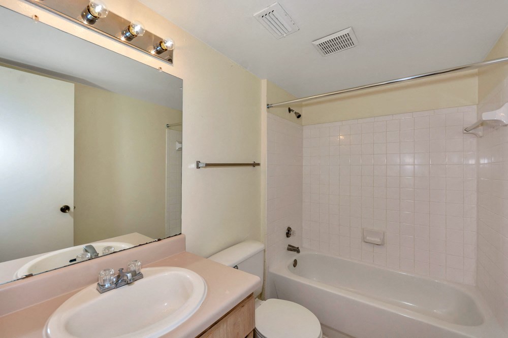 A white sink is on a counter under lights.