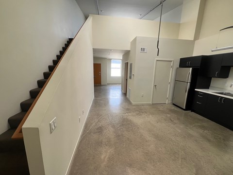 A kitchen area with a staircase on the left side.