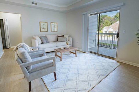 A living room with a grey couch, a grey chair and a coffee table.