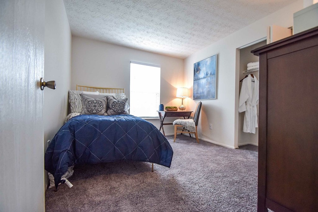 A bedroom with a bed, dresser, and mirror.