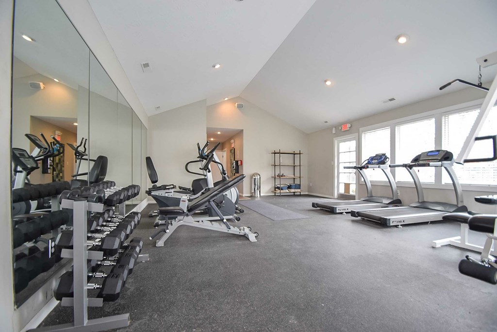 A spacious gym with a variety of equipment including treadmills, weights, and exercise machines.