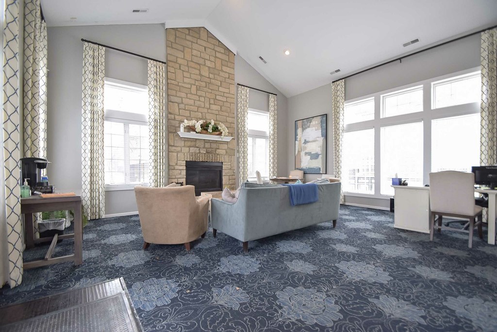 A grey carpeted room with a dining table and chairs.
