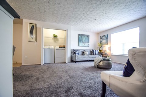 A bedroom with a bed, chair, and painting on the wall.