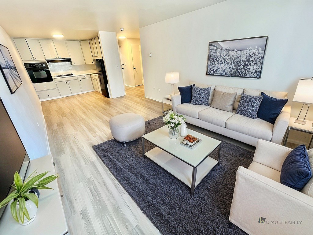 A sunny room with white chairs and a grey carpet.
