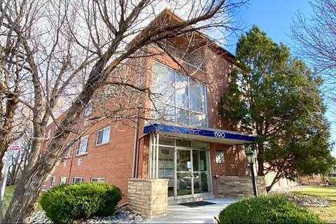 A brick building with a blue awning and the number 190 on it.