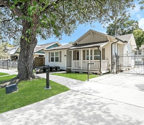 A house with a white fence and a black mailbox.