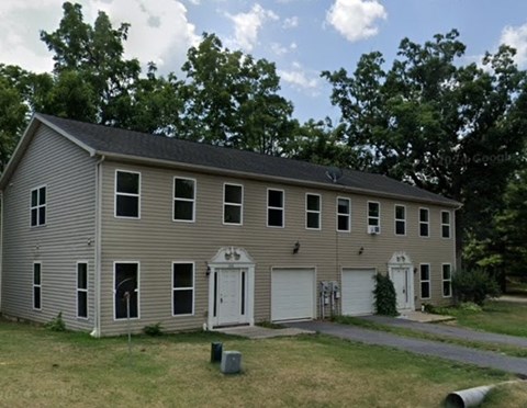 A two-story house with a garage on the side.