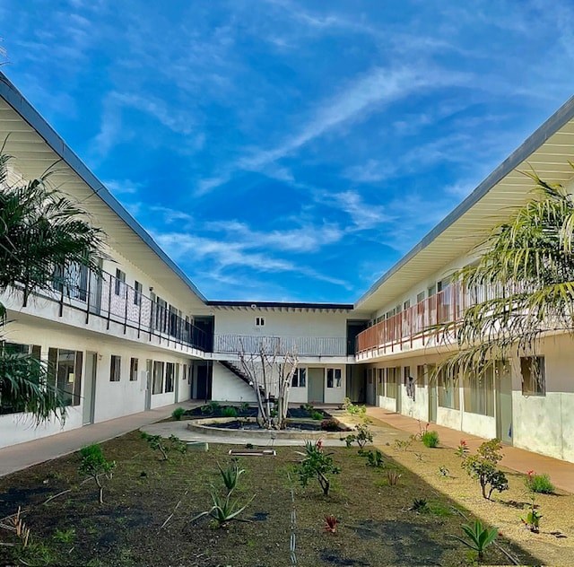 A courtyard surrounded by white buildings with a clear blue sky above.