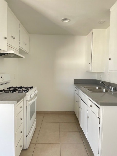 A kitchen with white cabinets and a stove top oven.