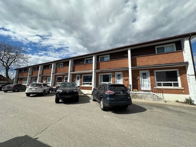 A parking lot with cars and a building in the background.