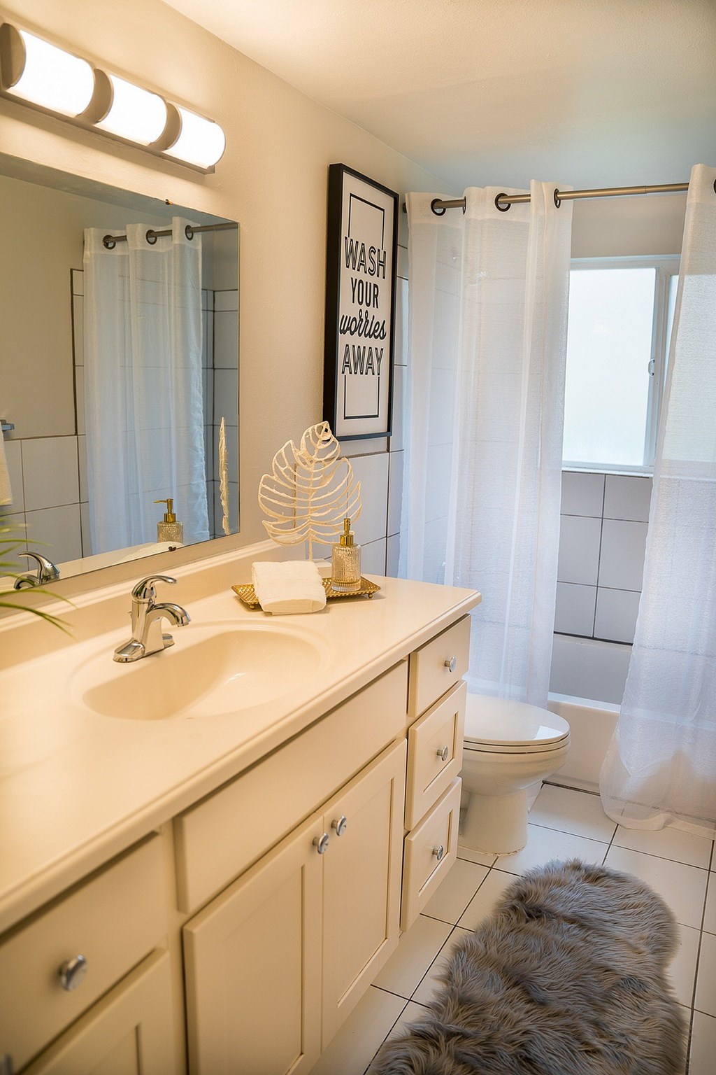 A bathroom with a sink, toilet, and a mirror.