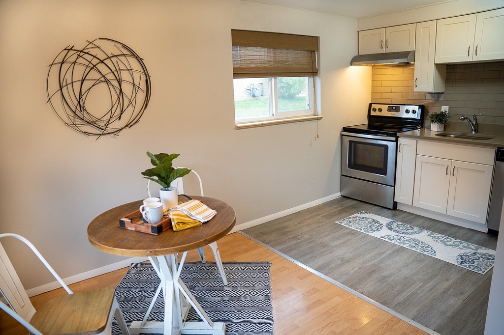 A modern kitchen with a round table and a white chair.